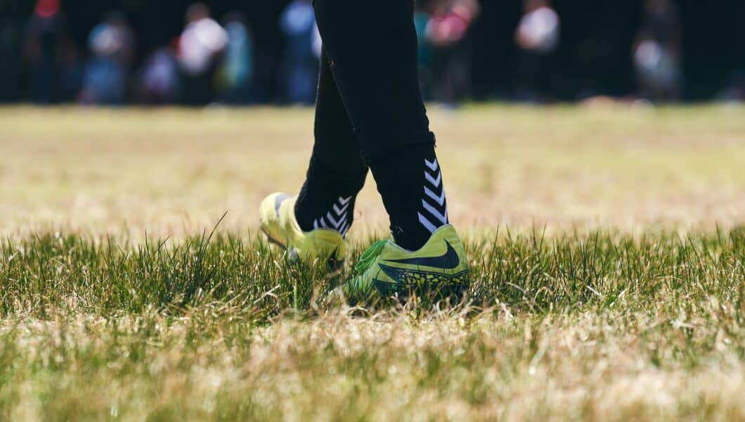 Voetballer met bal op een amateurveld