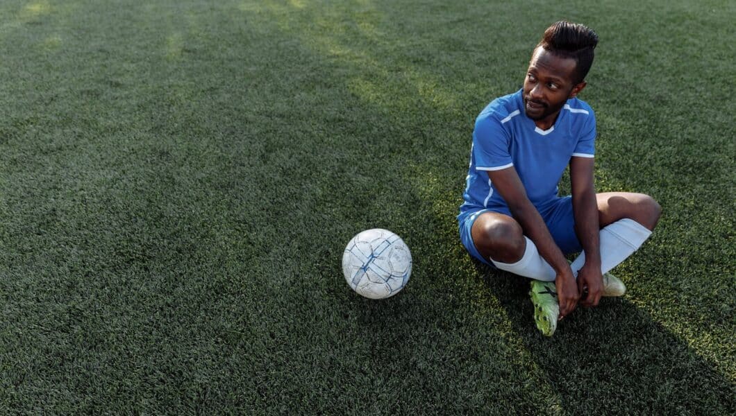 Voetballer rust uit op het veld na een wedstrijd