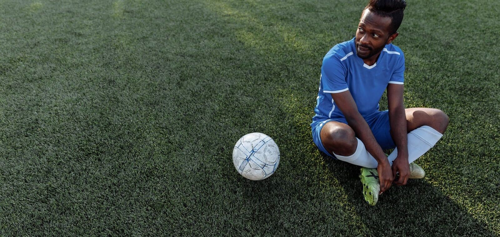 Voetballer rust uit op het veld na een wedstrijd