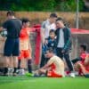 Jeugdvoetballers eten fruit tijdens een pauze langs het veld