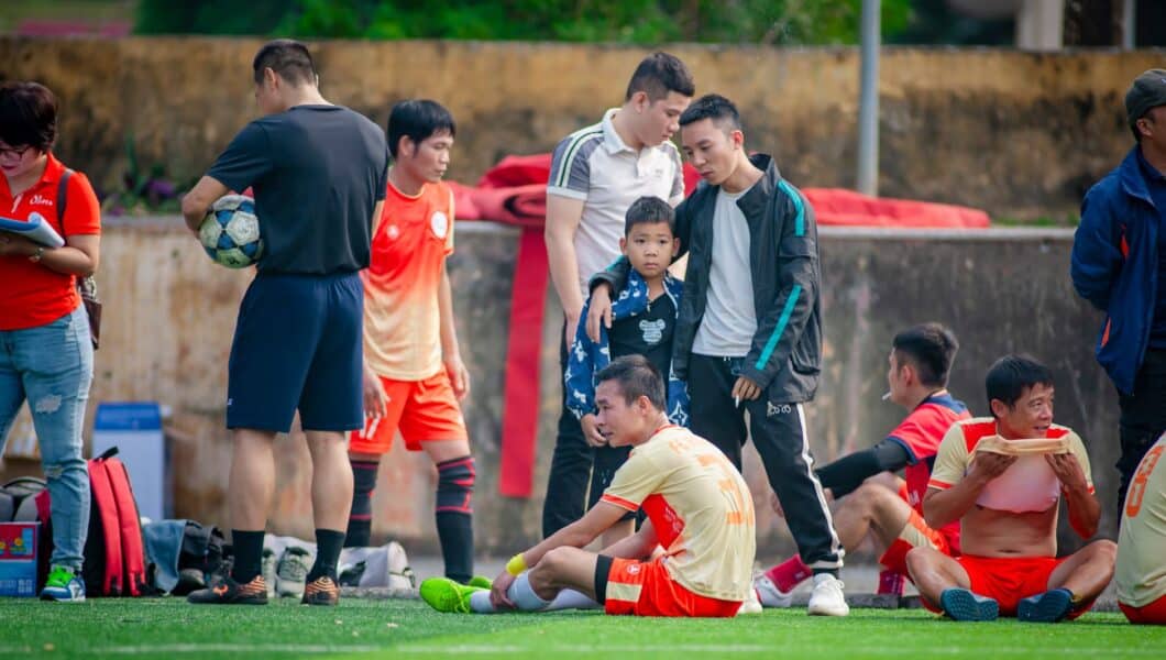Jeugdvoetballers eten fruit tijdens een pauze langs het veld