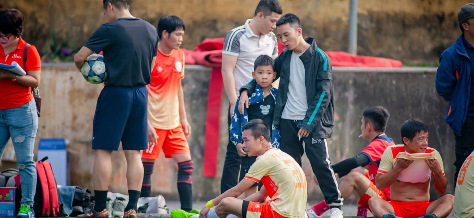 Jeugdvoetballers eten fruit tijdens een pauze langs het veld