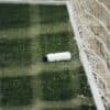 Voetballer drinkt uit een bidon tijdens een korte onderbreking op het veld