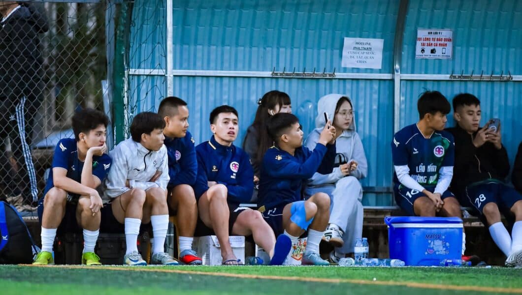 Voetbalteam op de bank met bidons tijdens een pauze in de wedstrijd