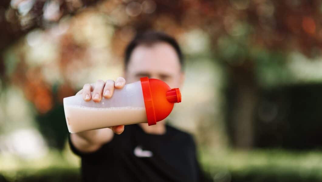 Voetballer drinkt een eiwitshake na een avondtraining