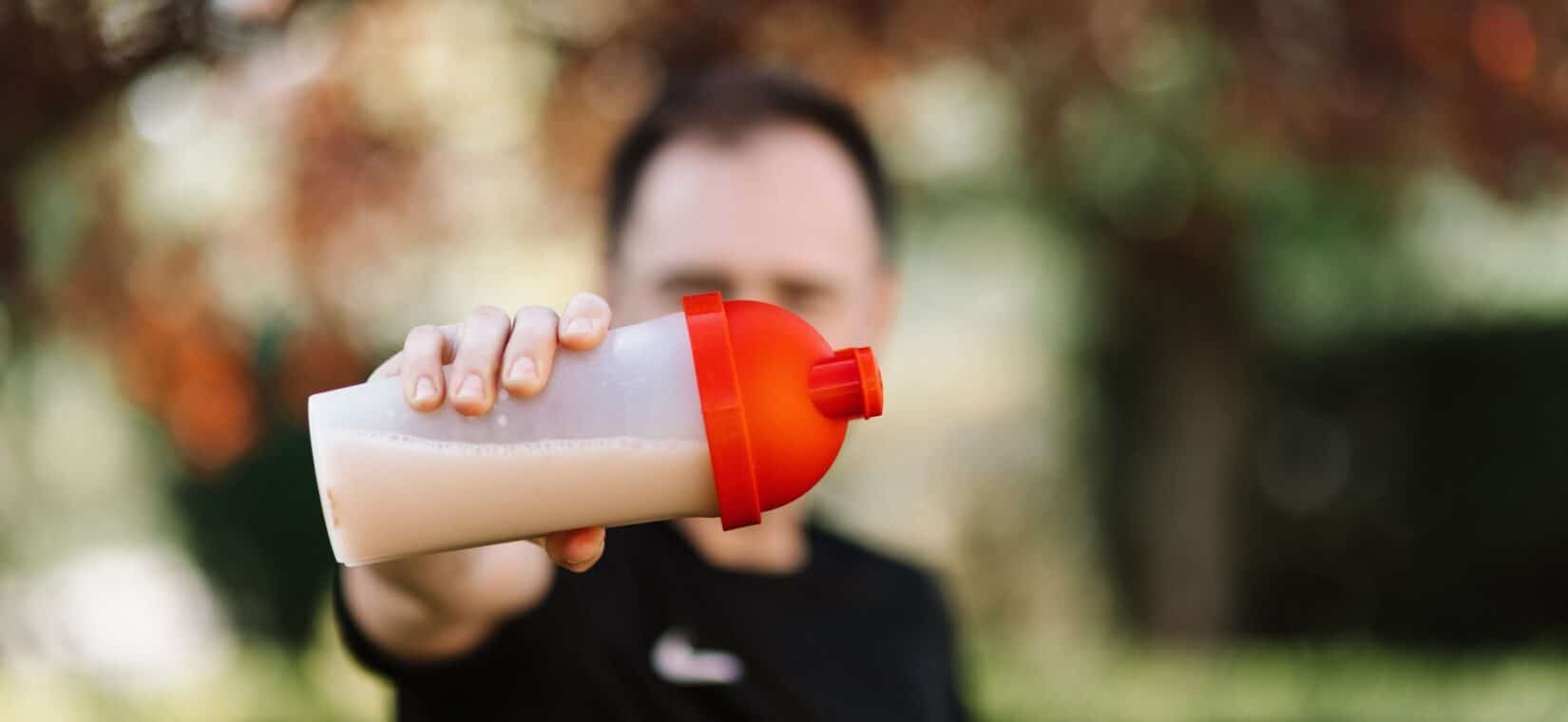 Voetballer drinkt een eiwitshake na een avondtraining