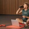 Voetballer drinkt een shake na de training op het veld