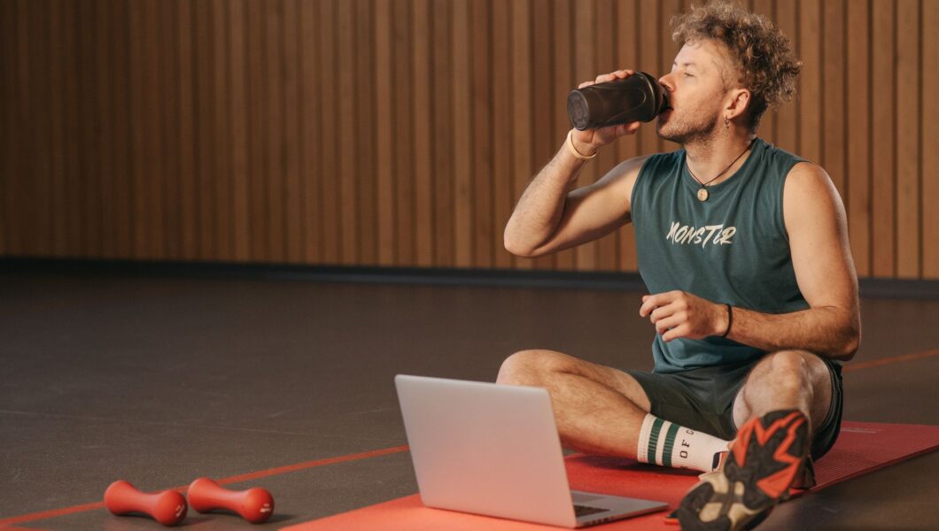 Voetballer drinkt een shake na de training op het veld