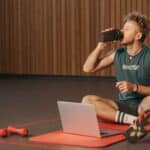 Voetballer drinkt een shake na de training op het veld