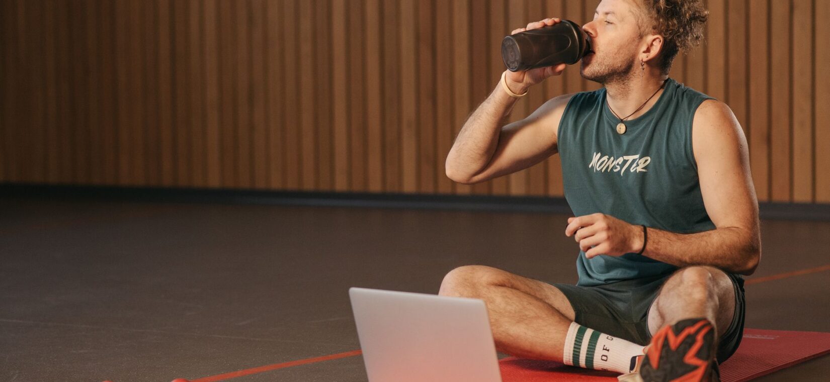 Voetballer drinkt een shake na de training op het veld
