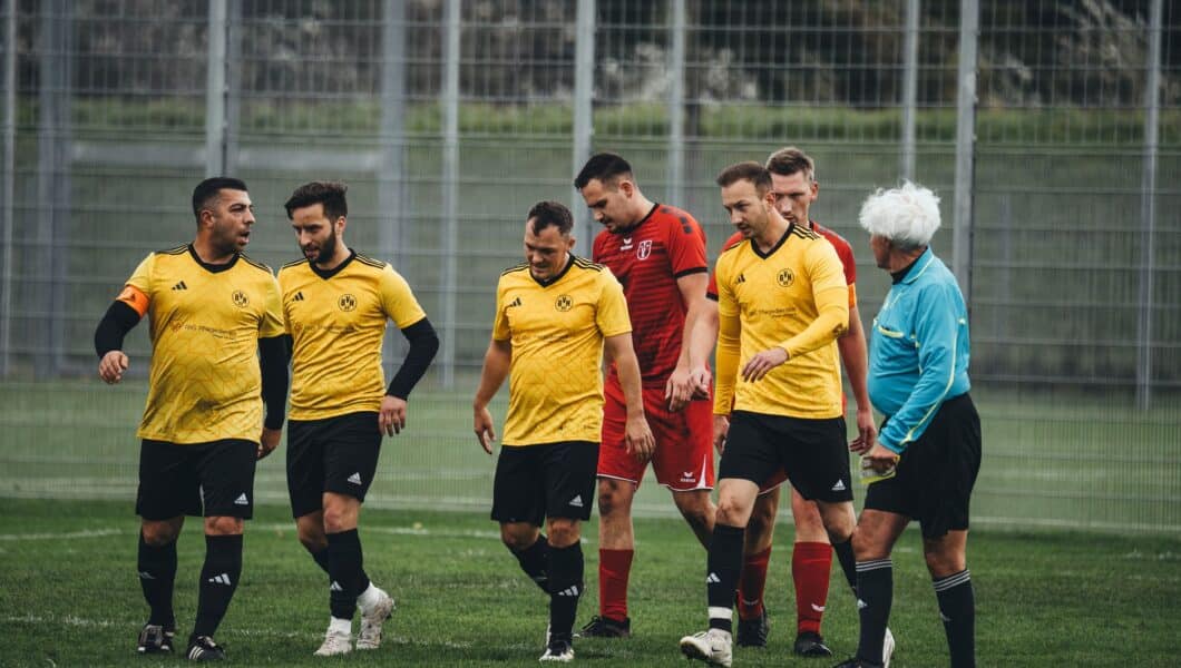 Voetballer eet een tussendoortje langs het veld voor de wedstrijd