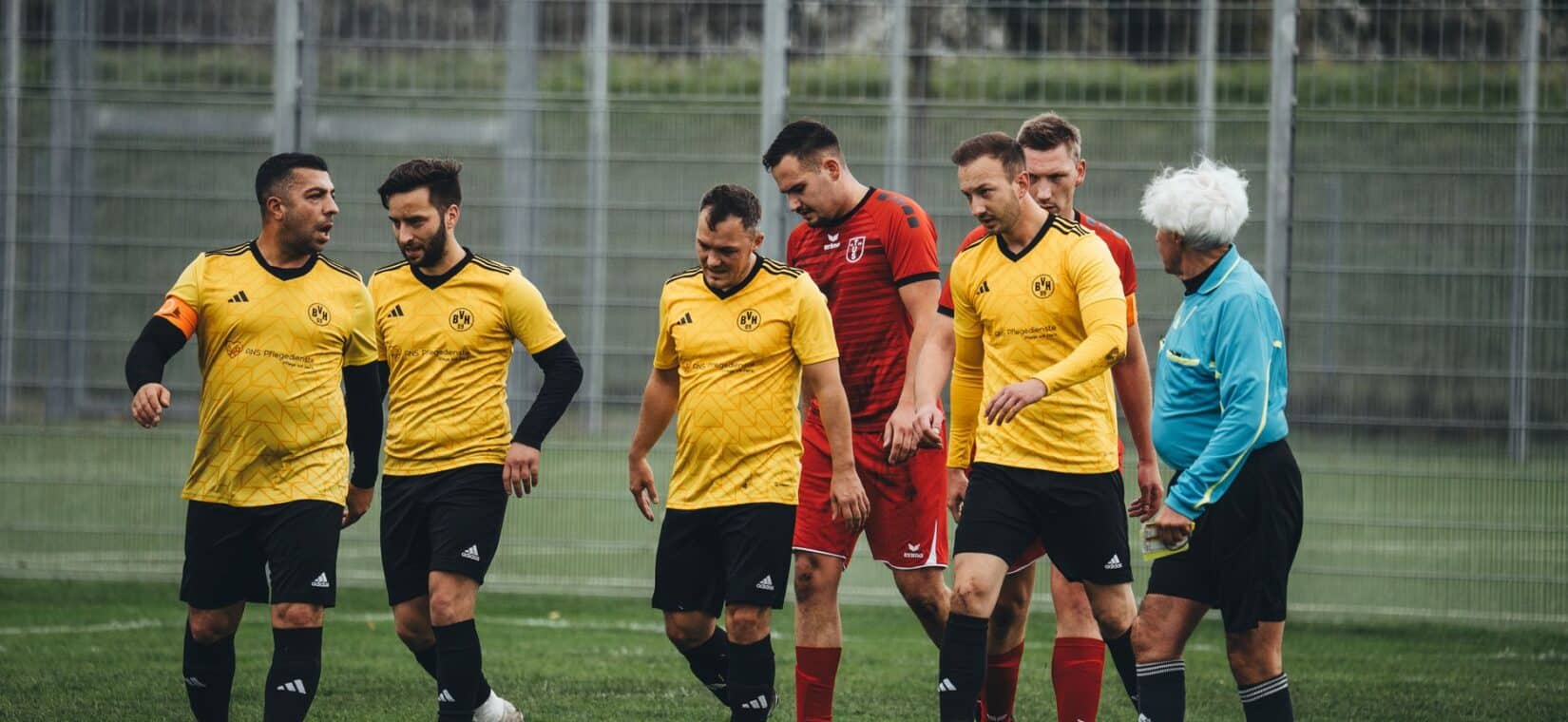 Voetballer eet een tussendoortje langs het veld voor de wedstrijd