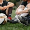 Vermoeide amateurvoetballer zit op het veld na afloop van de wedstrijd