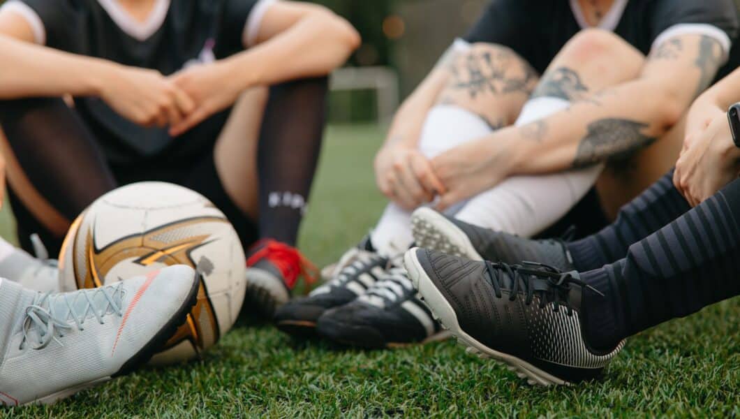 Vermoeide amateurvoetballer zit op het veld na afloop van de wedstrijd