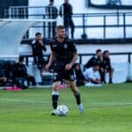 Vermoeide amateurvoetballer zit op het veld na de wedstrijd