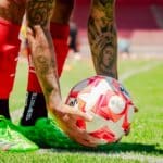 Voetballer gebruikt een foam roller op zijn bovenbeen na een training