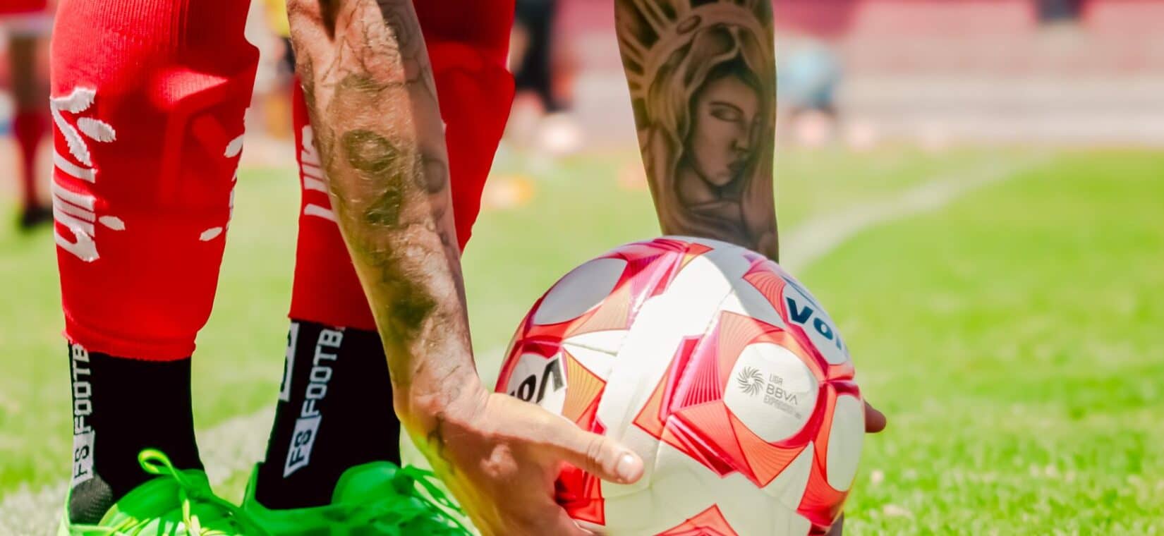 Voetballer gebruikt een foam roller op zijn bovenbeen na een training