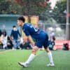Voetballer rekt zijn benen uit op het veld na afloop van een wedstrijd