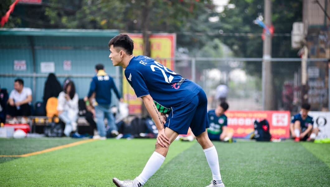 Voetballer rekt zijn benen uit op het veld na afloop van een wedstrijd