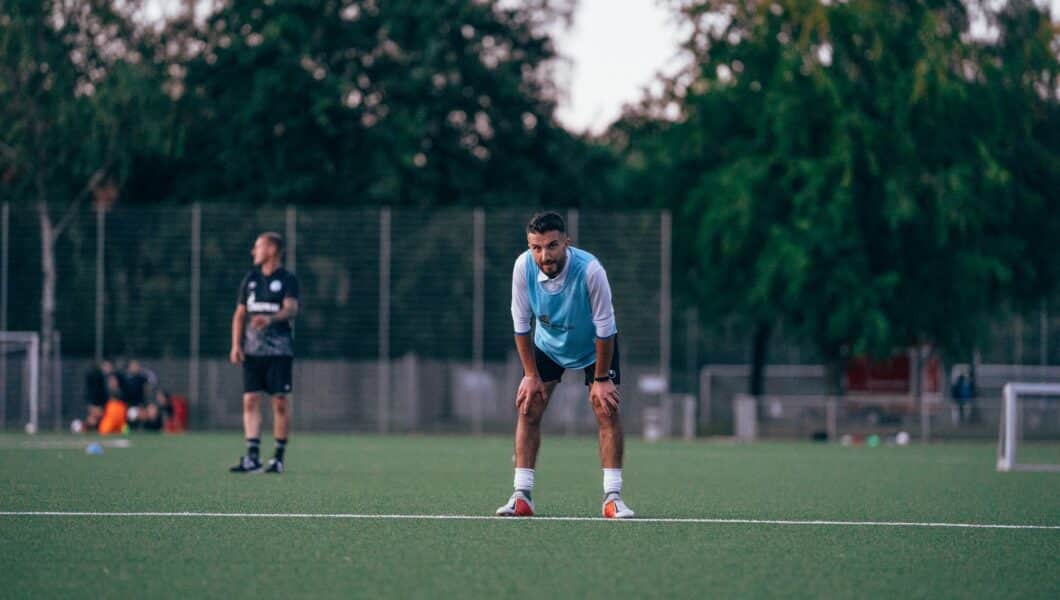 Amateurvoetballer eet een maaltijd na de training op het veld