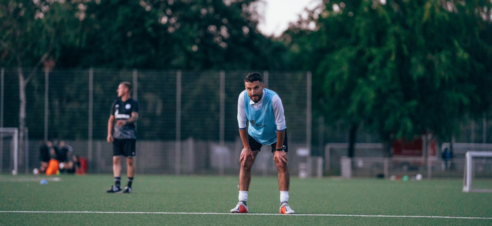 Amateurvoetballer eet een maaltijd na de training op het veld